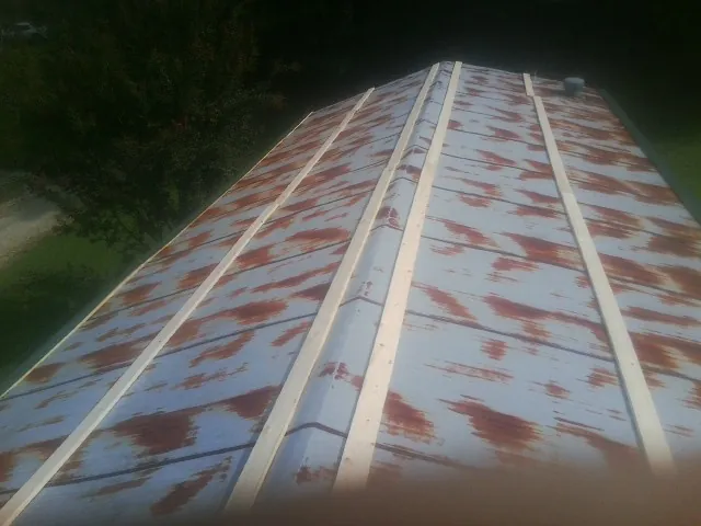 Rusted metal roof panels with new wood purlins before replacement — Storm Damage Roof Repair in Hall by Roofing Brothers
